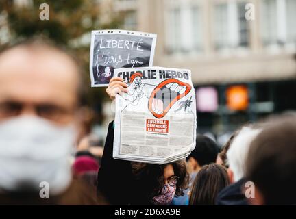 Strasburgo, Francia - Ott19, 2020: Donna con il giornale Charlie Hebdo in Place Kleber per rendere omaggio all'insegnante di storia Samuel Paty, decapitato il 16 ottobre dopo aver mostrato le caricature del profeta Muhammad in classe Foto Stock