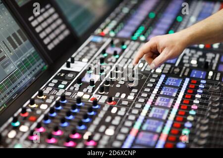 L'operatore regola i comandi del pannello del mixer audio nello studio di registrazione. Messa a fuoco selettiva. Foto Stock