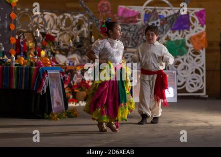 I giovani membri di el Grupo de Danza la speranza si esibiscono domenica 18 ottobre 2020 in una danza tipica della regione del Chiapas presso il Mighty Tieton Warehouse di Tieton, Washington. Le danze folcloristiche tradizionali sono state registrate per essere presentate virtualmente durante ottobre e novembre nel tentativo di limitare la diffusione del virus COVID-19 durante la celebrazione annuale della comunità di dia de los Muertos delle arti e delle scienze umane di Teton. Foto Stock