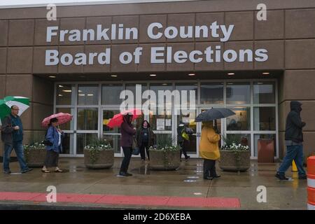 Columbus, Ohio, Stati Uniti. 19 Ott 2020. Centinaia di elettori della contea di Franklin, Ohio, hanno aspettato sotto la pioggia di votare lunedì mattina. La fila di persone al consiglio elettorale della contea di Franklin avvolta dietro l'edificio e i tempi di attesa sono stati di circa un'ora. Credit: John Orvis/ZUMA Wire/Alamy Live News Foto Stock