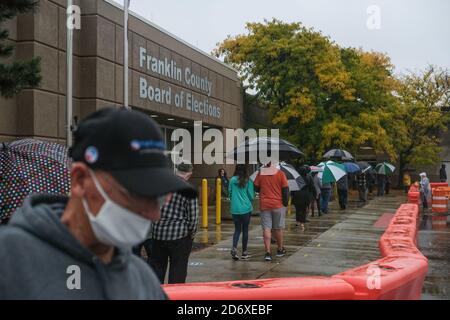 Columbus, Ohio, Stati Uniti. 19 Ott 2020. Centinaia di elettori della contea di Franklin, Ohio, hanno aspettato sotto la pioggia di votare lunedì mattina. La fila di persone al consiglio elettorale della contea di Franklin avvolta dietro l'edificio e i tempi di attesa sono stati di circa un'ora. Credit: John Orvis/ZUMA Wire/Alamy Live News Foto Stock