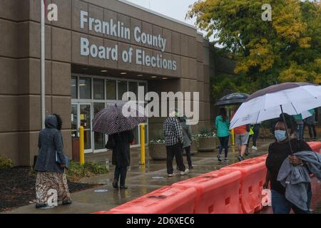 Columbus, Ohio, Stati Uniti. 19 Ott 2020. Centinaia di elettori della contea di Franklin, Ohio, hanno aspettato sotto la pioggia di votare lunedì mattina. La fila di persone al consiglio elettorale della contea di Franklin avvolta dietro l'edificio e i tempi di attesa sono stati di circa un'ora. Credit: John Orvis/ZUMA Wire/Alamy Live News Foto Stock