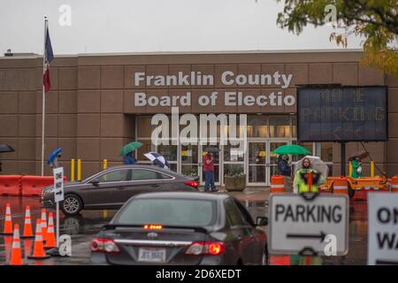 Columbus, Ohio, Stati Uniti. 19 Ott 2020. Centinaia di elettori della contea di Franklin, Ohio, hanno aspettato sotto la pioggia di votare lunedì mattina. La fila di persone al consiglio elettorale della contea di Franklin avvolta dietro l'edificio e i tempi di attesa sono stati di circa un'ora. Credit: John Orvis/ZUMA Wire/Alamy Live News Foto Stock