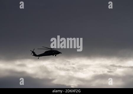 Un elicottero Sikorsky SH-60 Seahawk dalla silhouette, della Carrier Air Wing Five, che vola vicino alla base aerea navale, alla base aerea di Atsugi, Kanagawa, Giappone. Foto Stock