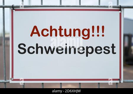 Segno con l'iscrizione 'Achtung Schweinepiest' (attenzione peste suina africana) Su una recinzione ad una fattoria in Germania Foto Stock