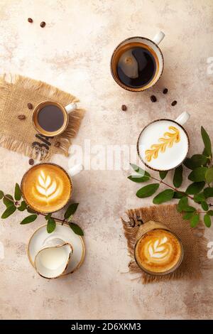 Tazze da caffè latte, espresso, cappuccino su sfondo color pastello vintage beige Foto Stock