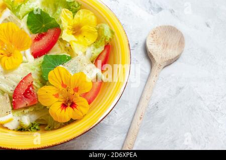 Cibo colorato, insalata di verdure fresche di colore giallo in ciotola di ceramica, con cucchiaio di legno. Concetto di stile di vita sano Foto Stock