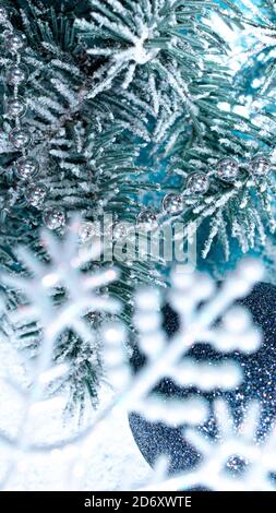 Foto verticale di Capodanno di fiocchi di neve, rami di abete rosso nella neve. Splendido scenario festivo coperto di neve 2021 Foto Stock