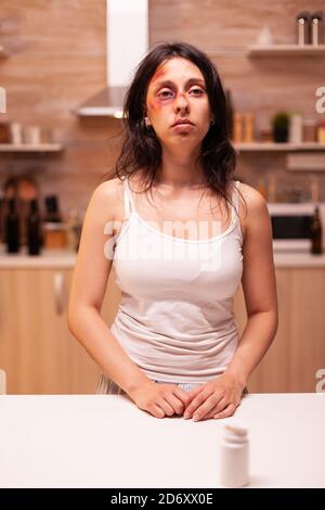 Donna depressa abusata perché violento marito alcolico in casa. L'uomo che abusa ferendo terrorizzata moglie impotente, vulnerabile, impaurita, picchiata e in preda al panico che vive nel terrore e nella pressione Foto Stock