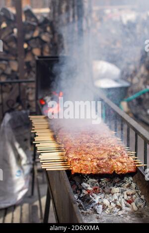 Un sacco di kebab in fila sulla griglia. Kebabs strung su spiedini di legno Foto Stock