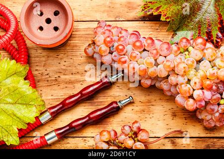 Hookah con uva tabacco.fragrante hookah uva su sfondo di legno Foto Stock