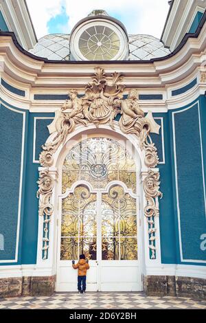 Tsarskoye Selo, Pushkin, San Pietroburgo, Russia - 10.07.2020 : piccolo ragazzo che guarda nella porta di vetro del padiglione della Grotta nel parco di Caterina Foto Stock