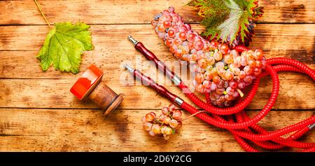 Hookah con uva tabacco.fragrante hookah uva su sfondo di legno Foto Stock
