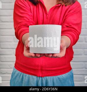 Concetto di malattia intestinale, avvelenamento alimentare e problemi di diarrea. Ragazza con rotoli di carta igienica in mani, primo piano Foto Stock