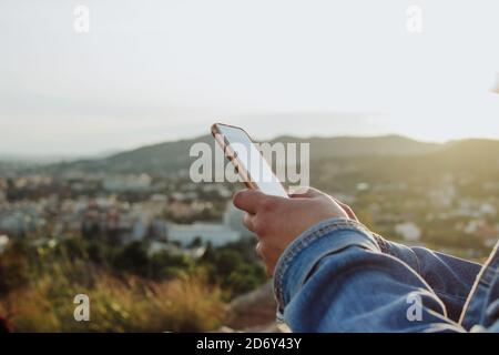 giovane donna che usa il telefono cellulare in campagna. Concetto di connettività Internet rurale. Foto Stock