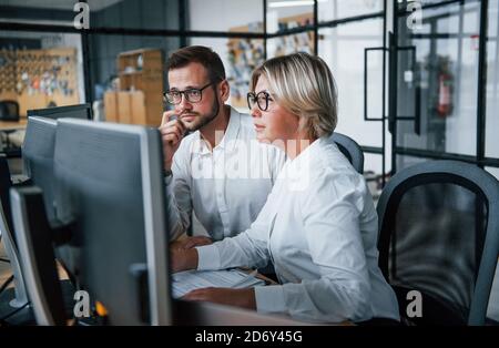 Due agenti di magazzino in abiti formali lavora in ufficio con mercato finanziario Foto Stock
