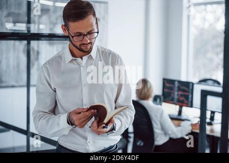 Ritratto di giovane uomo d'affari in abiti formali che si leva in piedi ufficio Foto Stock