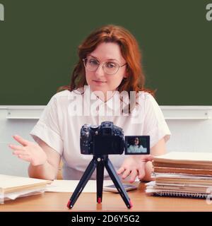 Una insegnante di sesso femminile conduce una lezione online in una classe scolastica. Imparare a scuola tramite video, stile di vita Foto Stock