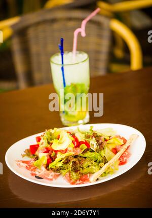 mojito fresco in bicchiere e insalata sul piatto al caffè tabella Foto Stock