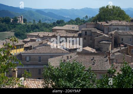 Vista sulla parte alta della città di Urbino. Sullo sfondo un'antica chiesa su una collina verde Foto Stock