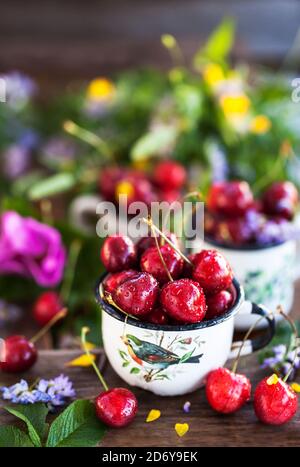 Ciliegie fresche mature in tazza su sfondo estivo Foto Stock