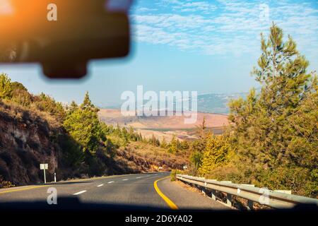 Guida di un'auto su una strada di montagna nel nord di Israele. In auto. Vista dall'auto al paesaggio montano Foto Stock