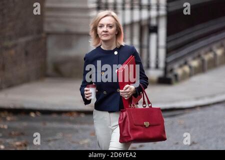 Liz Truss cammina fino a Downing Street per una riunione del gabinetto il 20 ottobre 2020, indossando una giacca blu navy e tenendo i ministri, cartella rossa.