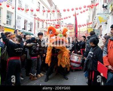 Un drago raccoglie offerte da negozi e ristoranti in Gerrard Street a Chinatown, nel centro di Londra, come parte delle celebrazioni per il Capodanno cinese. Foto Stock