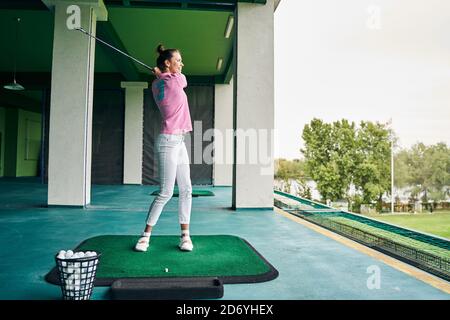 Calzare la giovane sportiva che pratica i suoi movimenti di oscillazione Foto Stock