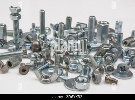 Chromeplated bulloni e dadi su sfondo bianco Foto Stock