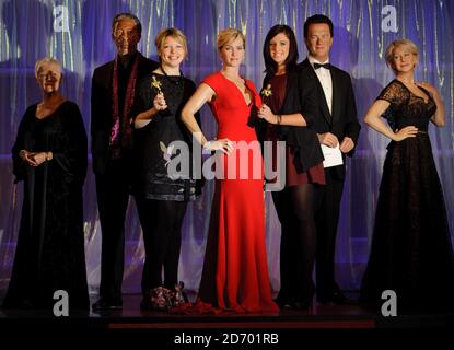 I dipendenti Laura Burks (a sinistra) e Gemma Keegan (a destra) sono stati raffigurati con le statue dei vincitori Judi Dench, Morgan Freeman, Kate Winslet, Tom Hanks e Dame Helen Mirren all'apertura della festa stagionale dei premi al Madame Tussauds di Londra. Foto Stock