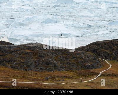 Turisti che ammirano il fiordo. Ilulissat Icefjord chiamato anche kangia o Ilulissat Kangerlua. L'icefjord è dichiarato patrimonio mondiale dell'UNESCO. America, N. Foto Stock