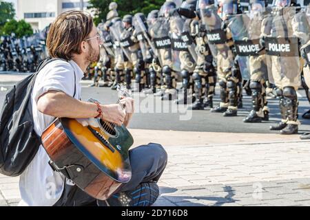 Miami Florida, Biscayne Boulevard, Free Trade Area of Americans Summit FTAA dimostrazioni, studente protestante maschio seduto polizia linea riot scudi ingranaggio Foto Stock