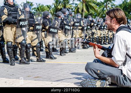 Miami Florida, Biscayne Boulevard, Free Trade Area of Americans Summit FTAA dimostrazioni, studente protestante maschio seduto polizia linea riot scudi ingranaggio Foto Stock