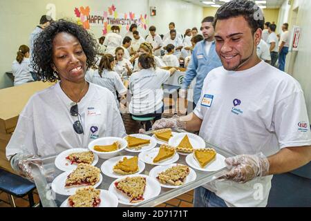 Miami Florida, Camillus House annuale pranzo Thanksgiving poveri senzatetto, volontari servire pasto pasti fette torta, Black Americans donna fema Foto Stock