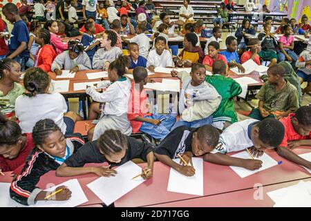 Miami Florida,Little Haiti Edison Park Elementary School,studenti di scrittura scrivere,ragazzi ragazzi ragazze bambini neri, Foto Stock