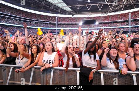 I fan si rallegrano durante la performance di Miley Cyrus durante il Summertime Ball di Capital FM al Wembley Stadium, Londra. Foto Stock