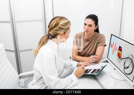 Prevenzione diagnosi di malattie cardiache in una donna durante una consultazione con un cardiologo esperto. Attacchi cardiaci e cure mediche Foto Stock