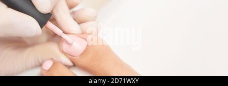 Manicure classica con unghie rosa su sfondo bianco. Concetto di trattamento spa Foto Stock