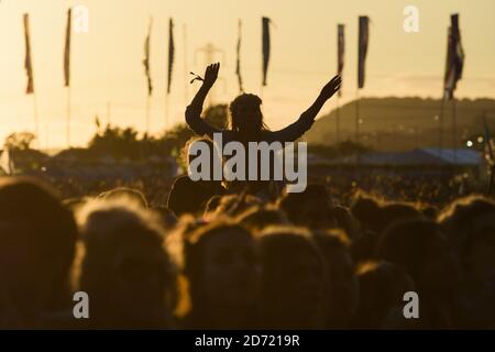 La folla guarda la Bastiglia che si esibisce al tramonto, sull'altro palco al Glastonbury Festival, presso la Worthy Farm di Somerset. Foto Stock