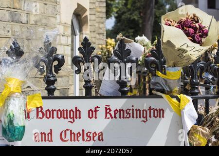 Un cartello stradale nel quartiere di Kensington e Chelsea, Londra, con fiori e tributi alle vittime dell'incendio della Torre di Grenfell attaccato. Il quartiere di Kensington e Chelsea è uno dei più polarizzati in Gran Bretagna, con alcuni dei più costosi immobili nel Regno Unito a pochi passi da molti dei quartieri più poveri del paese - compresa l'area intorno alla Torre di Grenfell. Data immagine: Mercoledì 12 luglio 2017. Il credito fotografico dovrebbe essere: Matt Crossick/ EMPICS Entertainment. Foto Stock