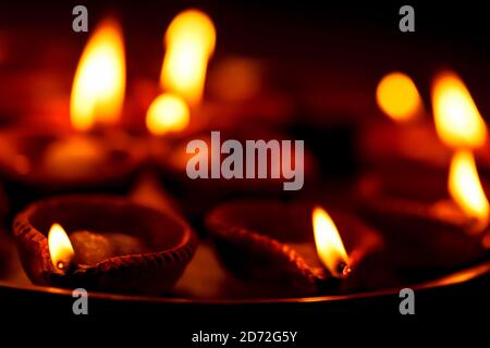 Happy Diwali sfondo con spazio per la copia. Clay diya o tradizionali lampade ad olio accese o che bruciano di notte. Concetto per biglietti di auguri, festival indù indiano Foto Stock