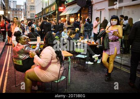 La gente mangia e beve odoors a Soho, Londra, mentre le restrizioni di blocco del coronavirus sono attenuate attraverso l'Inghilterra. Molte strade di Soho erano pedonali per la notte, e bar e ristoranti hanno aggiunto posti a sedere extra all'aperto. Data immagine: Domenica 5 luglio 2020. Il credito fotografico dovrebbe essere: Matt Crossick/Empics Foto Stock