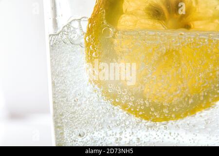 Dettaglio di vetro con acqua frizzante e fetta di limone frontale visualizza Foto Stock