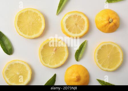 Dettaglio di diversi tagli di limone su tavola bianca. Vista dall'alto. Composizione orizzontale. Foto Stock