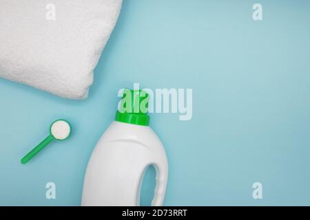 Flacone detergente liquido, polvere e asciugamano bianco su sfondo blu Foto Stock
