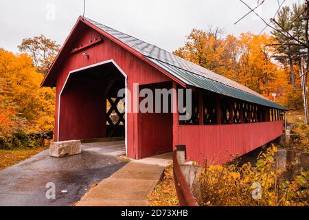 Bellissimo ponte coperto Vermont circondato da colorate foglie autunnali. Foto Stock