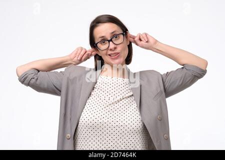 Giovane donna caucasica facendo simpatico grimace scimmia tirando le orecchie Foto Stock