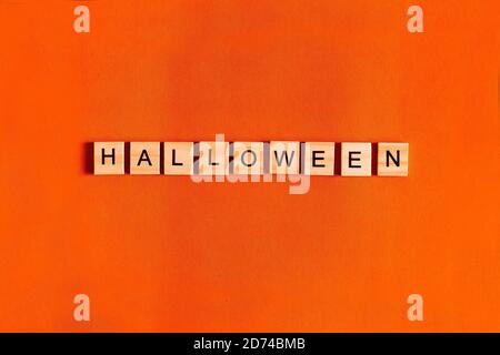 Scritta Halloween su sfondo arancione con silhouette di carta nera, pipistrelli, zucca, ragno. Il concetto di Halloween. La vista dall'alto Foto Stock