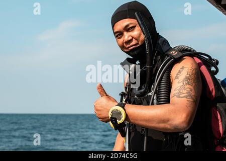 Isole Calventuras, Ngwesaung, Myanmar, 29 dicembre 2019: Ritratto di un istruttore locale birmano subacqueo con tatuaggi che danno i pollici Foto Stock